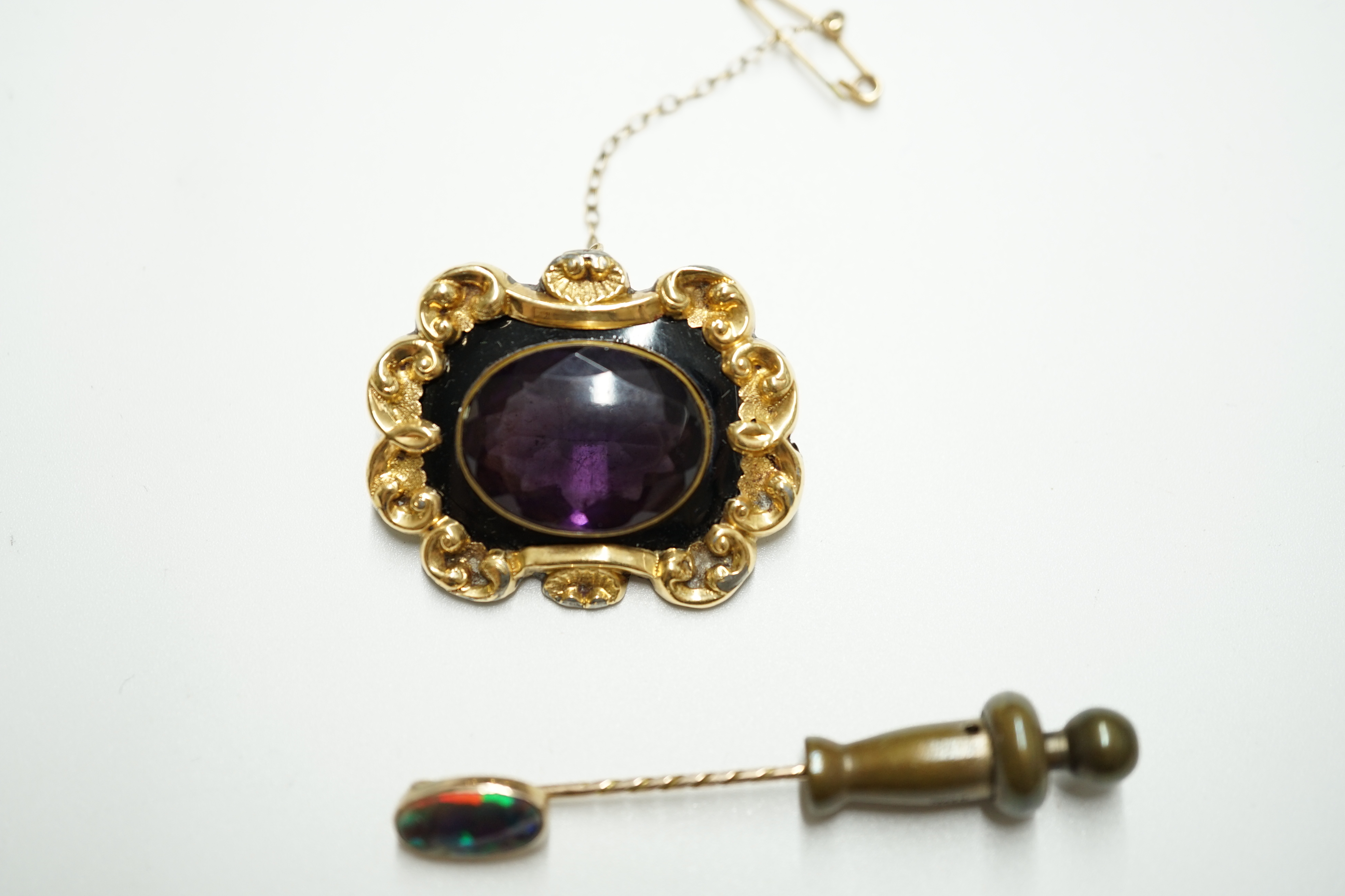 A Victorian gold plated and single stone oval amethyst paste set mourning brooch, 34mm, together with a yellow metal and black opal set stick pin. Condition - poor to fair